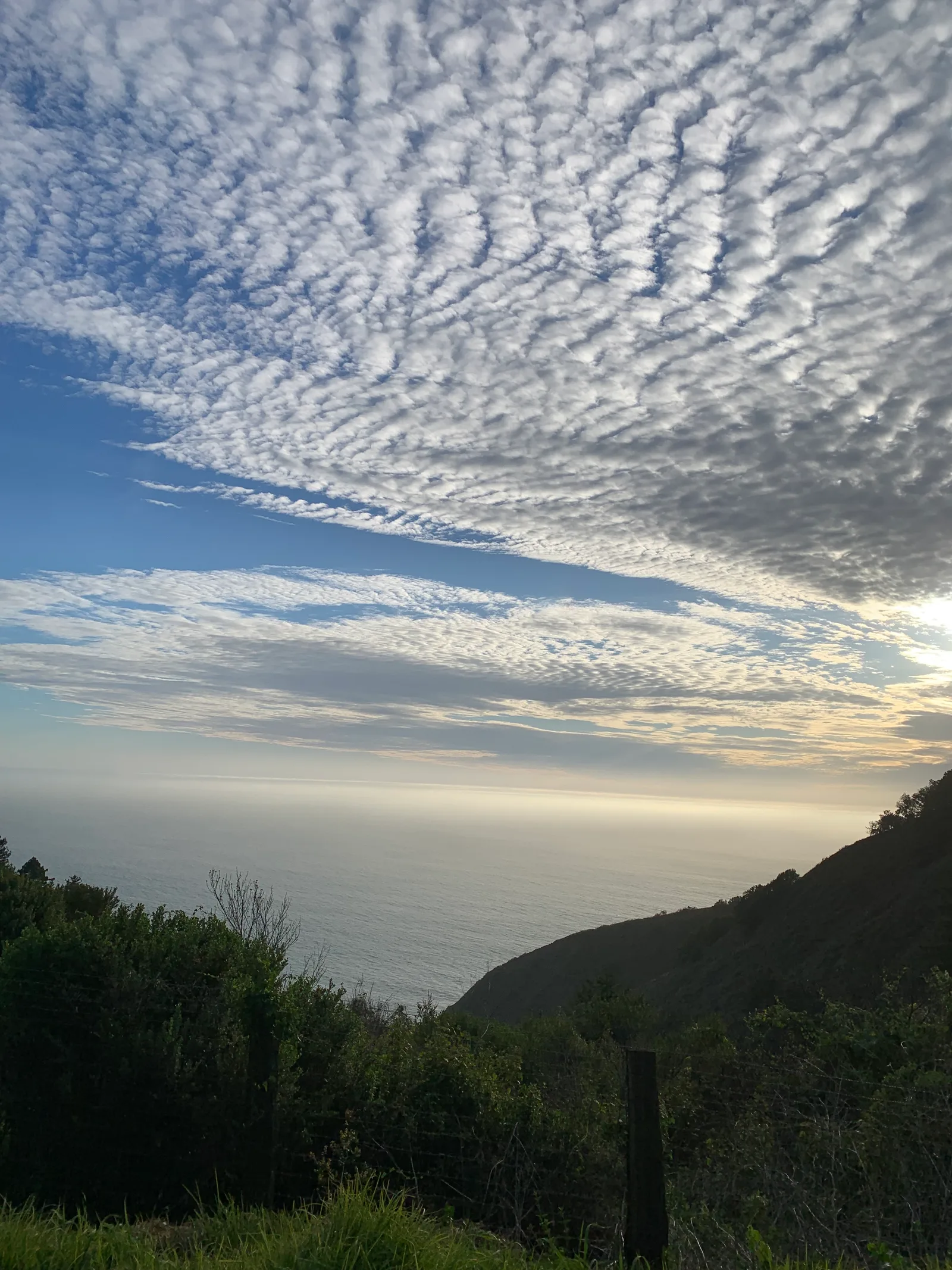 Textured clouds above a quiet ocean horizon